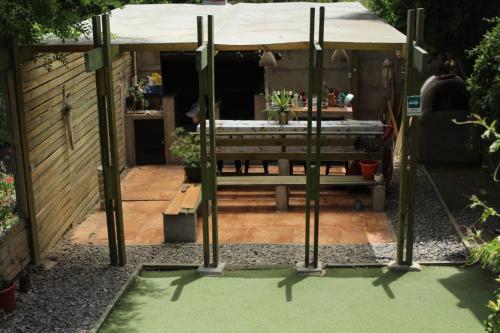 a garden with a pavilion with a table and a bench at Algarrobo Lodge in Algarrobo