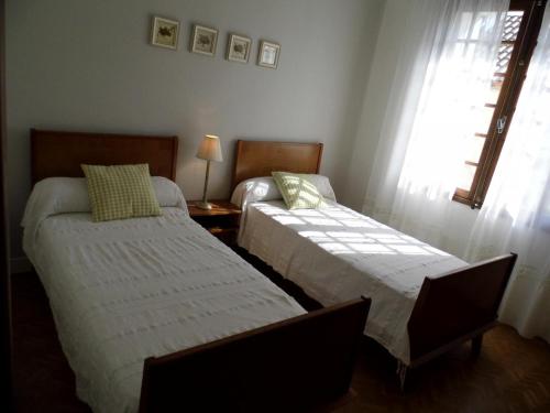 - une chambre avec 2 lits et une fenêtre dans l'établissement Charmante maison au cœur du Périgord avec jardin clos, Wifi, garage, proche de la Dordogne et sites historiques - FR-1-616-42, au Buisson de Cadouin