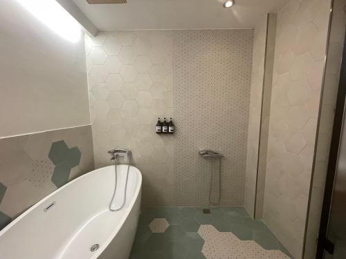 a bathroom with a tub and a shower with a toilet at Green Inn Kaohsiung in Kaohsiung