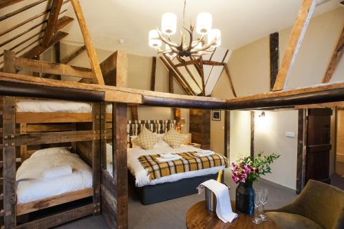 a bedroom with a bunk bed and a table at The White Hart, South Harting in Petersfield