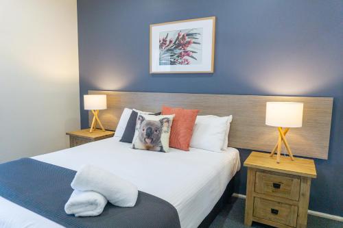 a bedroom with a large bed with two lamps at Port Stephens Koala Sanctuary in One Mile