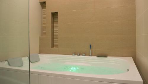 a bathroom with a bath tub with a mirror at Hotel Palonegro in Bucaramanga