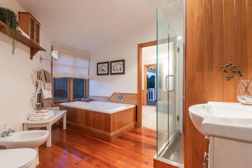 een badkamer met een bad, 2 wastafels en een douche bij Riverview Retreat in Riverhead