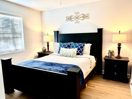 a bedroom with a black bed with blue sheets and pillows at Luxurious Bungalow in Payson in Payson