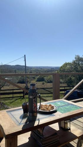 a table with a drink and a plate of food on it at Cabaña Sol y Luna in Villa Serrana