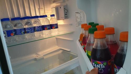 an open refrigerator filled with bottles of soda at New Modern Condo with Pool at Bangi in Kampong Tangkas