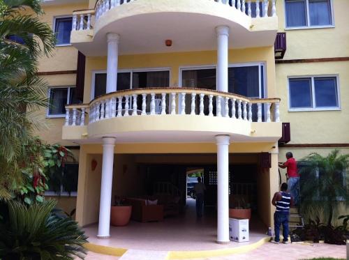 people standing in front of a house with a balcony at Royal Residence Apartment Condos in Cabarete