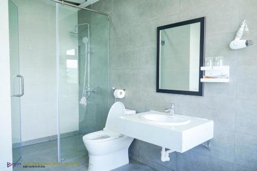 a bathroom with a sink and a toilet and a mirror at Khánh Phương Luxury in Châu Làng Chánh