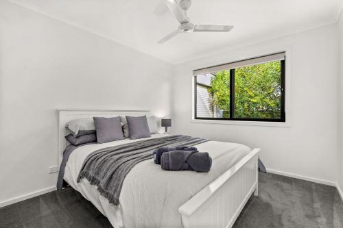 a white bedroom with a large bed and a window at Castlebay in Wimbledon Heights