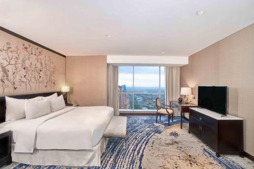 a hotel room with a bed and a large window at Vasa Hotel Surabaya in Surabaya