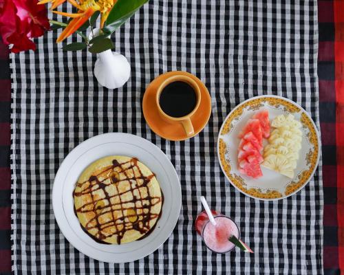 un tavolo con piatti di cibo e una tazza di caffè di The Gria Unique Ubud ad Ubud