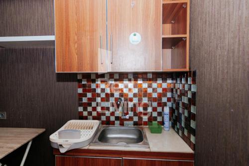 a small kitchen with a sink and a toilet at RedLiving Apartemen Bassura City - Aokla Property Tower Dahlia in Jakarta