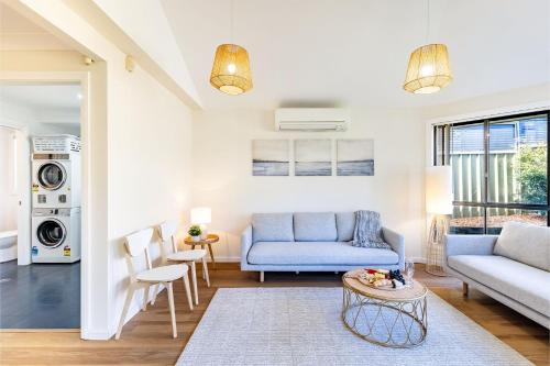 a living room with a blue couch and a table at Akoya House 122 Tomaree Rd Pet friendly linen air conditioning WiFi and boat parking in Shoal Bay