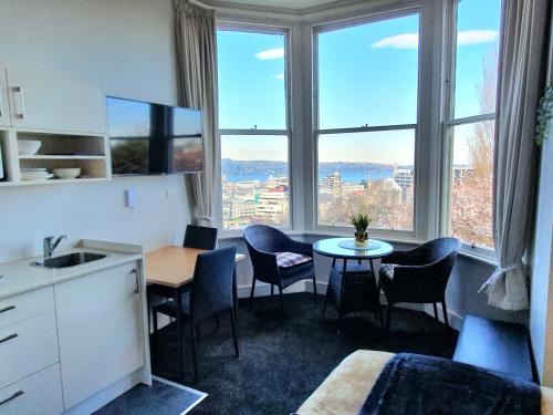 a kitchen with a table and chairs and a large window at Work Stay at 123 in Dunedin