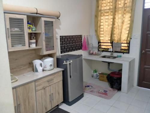 a kitchen with a refrigerator and a sink at Homestay CikguRose UMK in Bachok