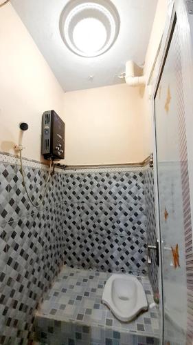 a bathroom with a toilet in a shower stall at Homestay Merpati Dieng Syariah RedPartner in Diyeng
