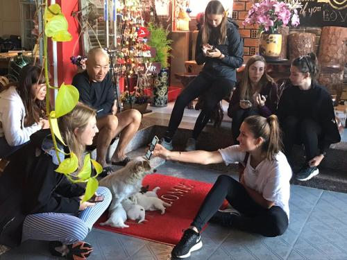 a group of people sitting on the floor with a dog at Redhouse Dalat Hotel in Da Lat