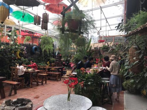 a group of people sitting at tables in a restaurant at Redhouse Dalat Hotel in Da Lat