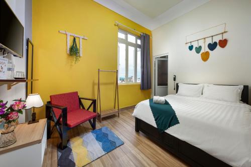 a bedroom with a bed and a red chair at Century House in Da Lat