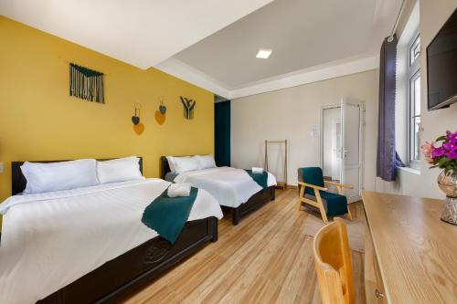 um quarto de hotel com duas camas e uma mesa em Century House em Da Lat