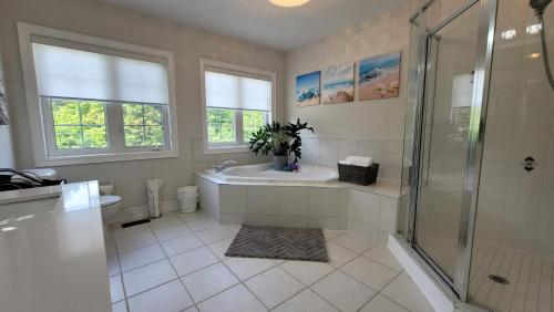 a bathroom with a shower and a tub and a sink at Rooms in Luxury Vaughan Home in Vaughan