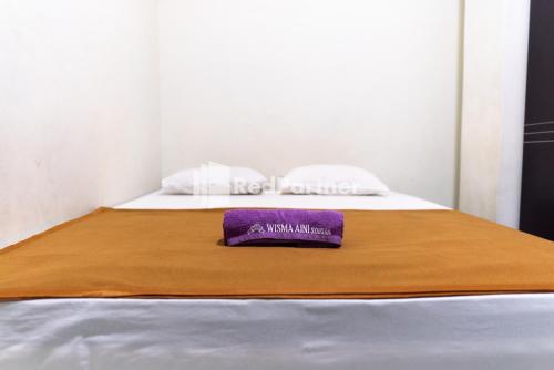 เตียงในห้องที่ Wisma Aini Syariah Mitra RedDoorz