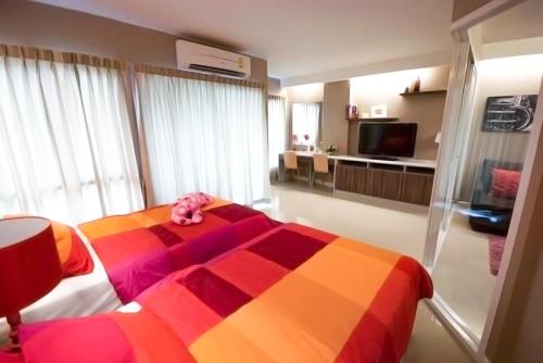 a bedroom with a colorful bed with a stuffed animal on it at Jpark Residences at Thammasat Rangsit in Ban Bang Phut (3)