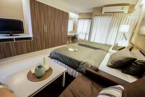 a hotel room with two beds and a couch at Jpark Residences at Thammasat Rangsit in Ban Bang Phut (3)