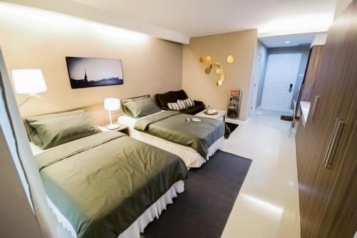 a hotel room with two beds and a couch at Jpark Residences at Thammasat Rangsit in Ban Bang Phut (3)