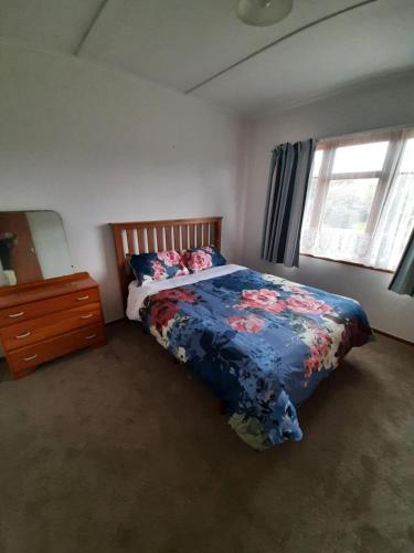 um quarto com uma cama, uma cómoda e uma janela em Mary's Place em Opotiki