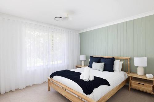 a bedroom with a large bed with blue and white pillows at Deja Blue in Anna Bay