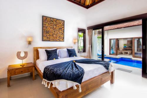 a bedroom with a large bed and a large window at Villa Joyosa in Seminyak