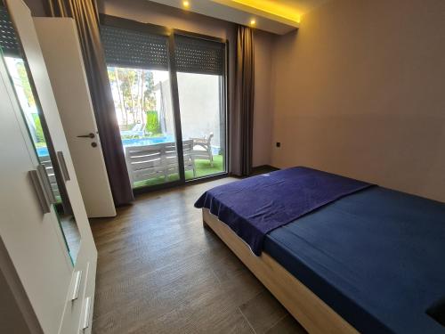1 dormitorio con cama y ventana grande en Özel havuzlu lüks villa, en Kusadasi