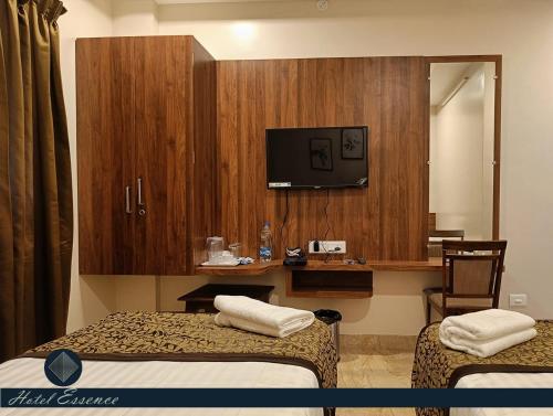 a hotel room with two beds and a tv at Hotel ESSENCE in Vellore