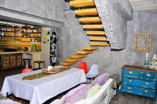 a dining room with a table and a staircase at Art House Sweet home in Shymkent