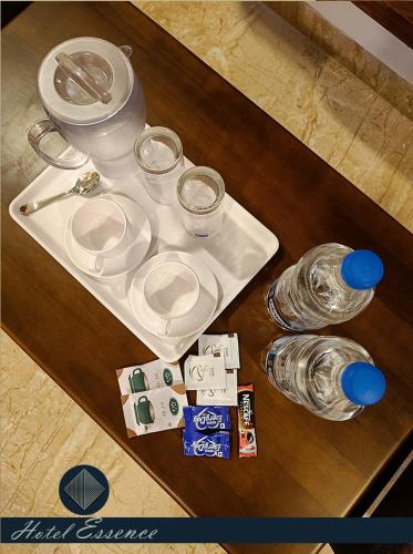 a table with a white plate and glasses on it at Hotel ESSENCE in Vellore