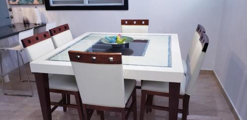 a white dining table with chairs and a bowl on it at M/H house (#1) cozy and beautiful house near the airport and the beach in Carolina