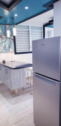 a kitchen with a white refrigerator and a table at M/H house (#1) cozy and beautiful house near the airport and the beach in Carolina