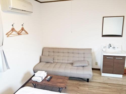 a living room with a couch and a sink at Guest House Tatara in Yasugi