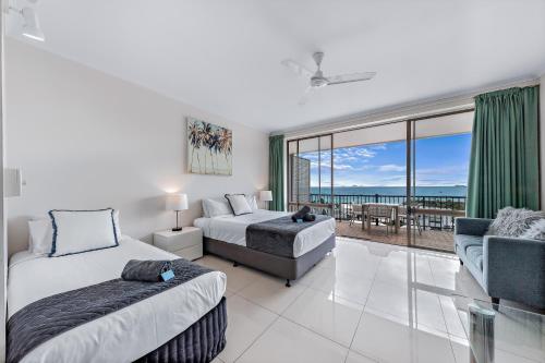 a bedroom with two beds and a view of the ocean at Central Ocean View Studio 27a in Airlie Beach
