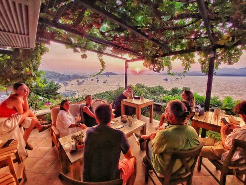 a group of people sitting at a table in a restaurant at Ece Hotel Sovalye Island in Fethiye