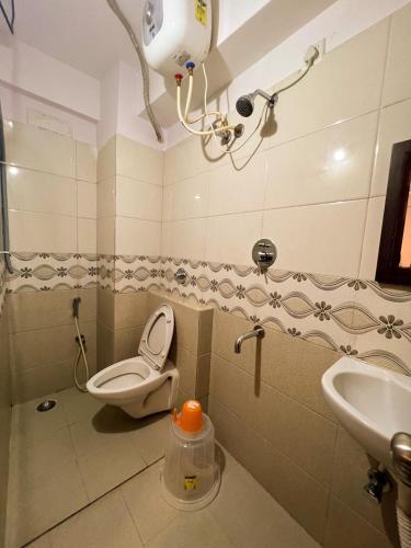 a bathroom with a toilet and a sink at Hotel InTourist by Agira Hotel in Bengaluru