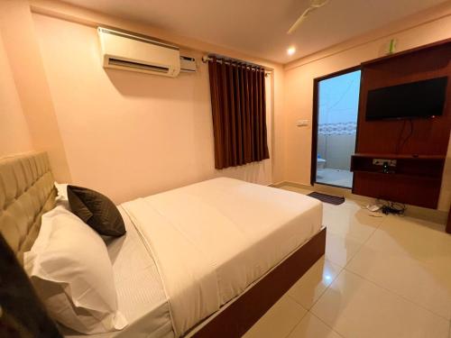 a bedroom with a bed and a television in it at Hotel InTourist by Agira Hotel in Bengaluru