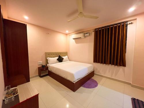 a bedroom with a bed and a ceiling fan at Hotel InTourist by Agira Hotel in Bengaluru