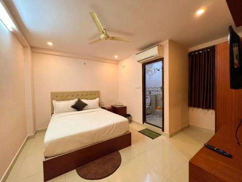 a bedroom with a bed and a ceiling fan at Hotel InTourist by Agira Hotel in Bengaluru