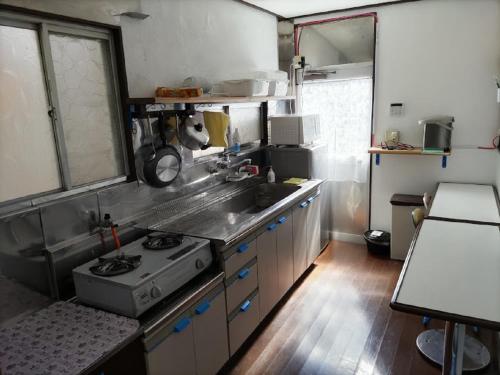 uma cozinha com um lavatório e um fogão em みのる民泊2号 em Shibushi