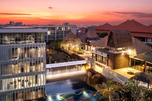 ヌサドゥアにあるThe Sakala Resort Bali All Suitesの夜間のプール付きの建物の景色を望めます。