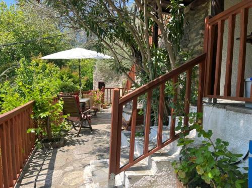 a balcony with an umbrella and a table and chairs at Valeondades in Valeontádes