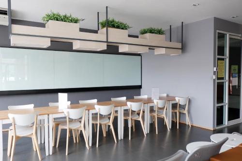 a conference room with a long table and white chairs at Jpark Residences at Thammasat Rangsit in Ban Bang Phut (3)