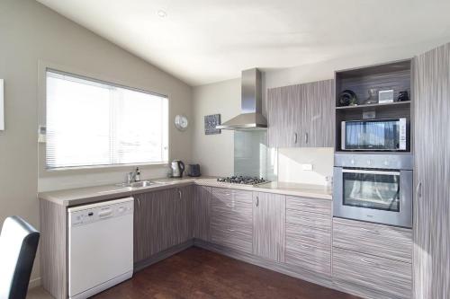 a kitchen with a sink and a stove top oven at Stunning Bob Lee Place in Wanaka